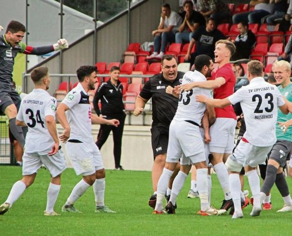 Der Moment, der für pure Ekstase im Lippstädter Lager sorgt: Paolo Maiella (verdeckt) nickt in der vierten Minute der Nachspielzeit zum Siegtreffer ein. Danach gibt es kein Halten mehr, sowohl bei den Verantwortlichen des SV wie auch auf der Tribüne bei den mitgereisten Fans. Links kommt Kapitän Christopher Balkenhoff „angeflogen“. Fotos: Heinke